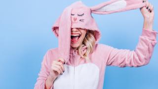 Blonde woman in pink bunny costume on a blue background