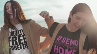 Close up of two girls at the beach, one wearing a Cruelty Free Forever t-shirt, one wearing a #SendSurvivorsHome t-shirt