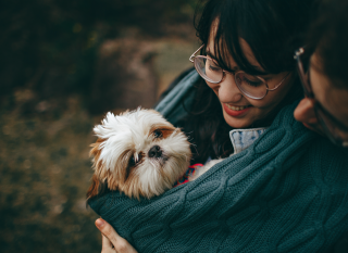 Woman hugging pet dog - Photo by Helena Lopes from Pexels