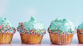 Three cupcakes with green icing and sprinkles