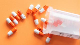 animal testing essay against Orange and white pills on an orange background